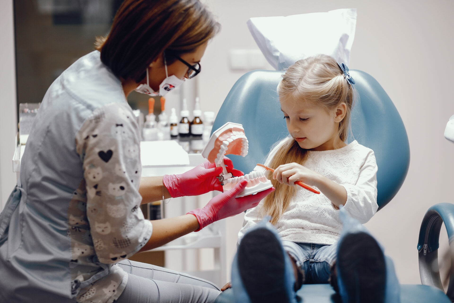 Dentist explaining Pediatric dentistry to little girl patient