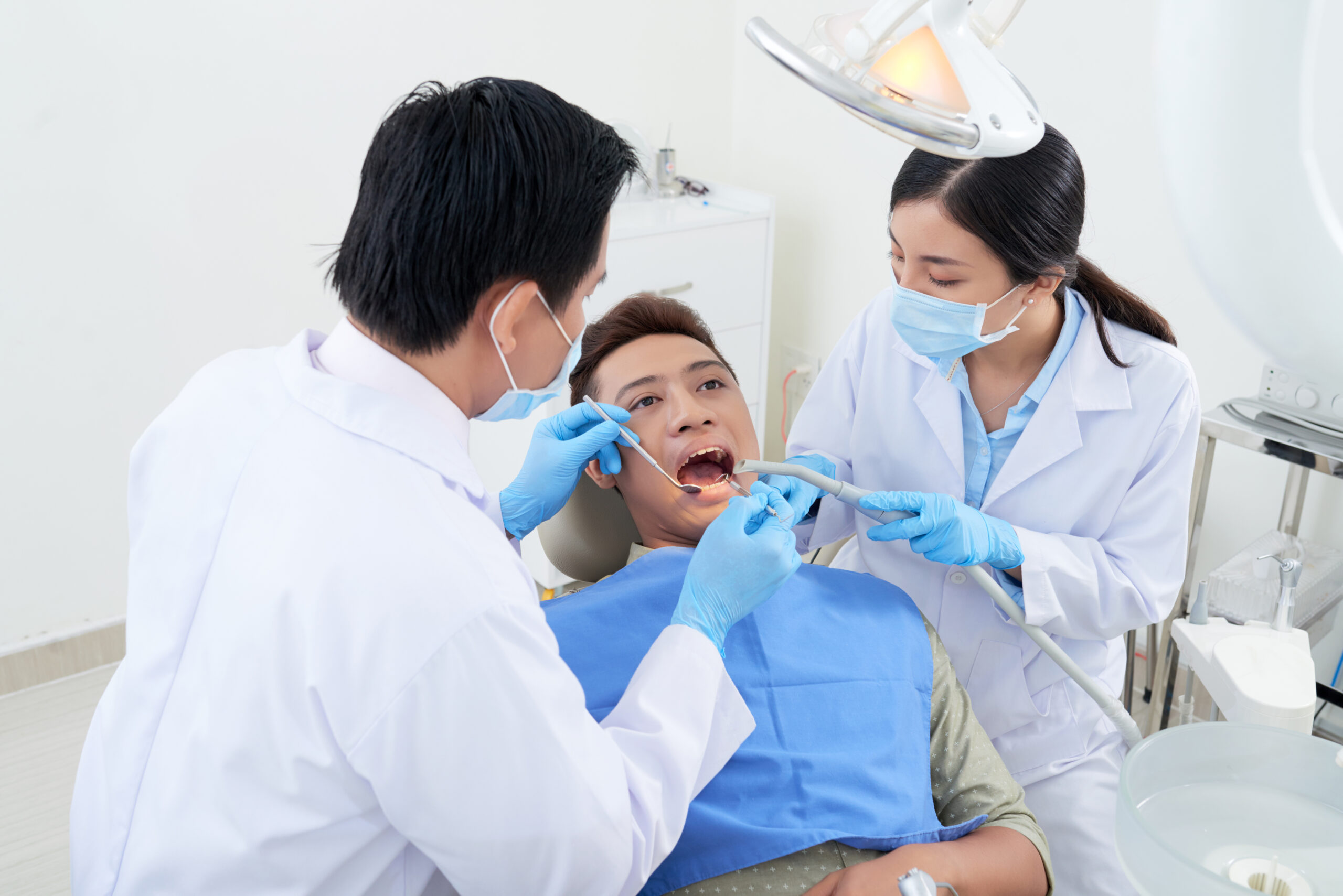 A patient with 2 dentist performing General Dentistry